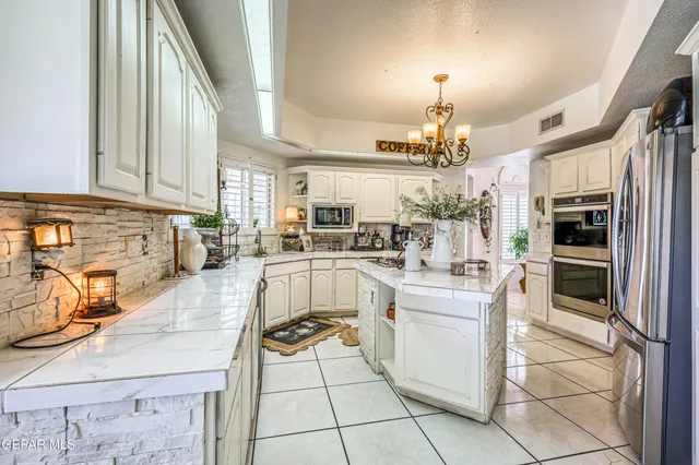a kitchen with stainless steel appliances granite countertop a refrigerator and a stove