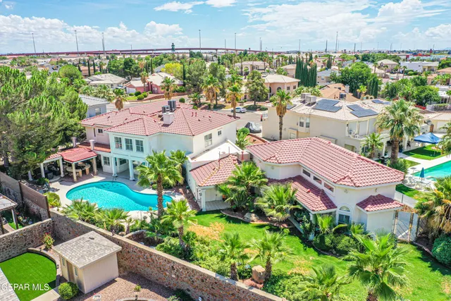 an aerial view of residential houses with outdoor space and trees