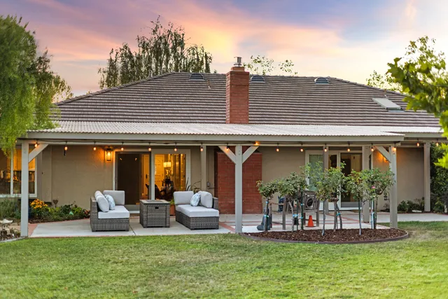a view of a house with furniture and garden