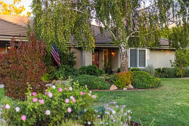 a front view of a house with a yard and potted plants
