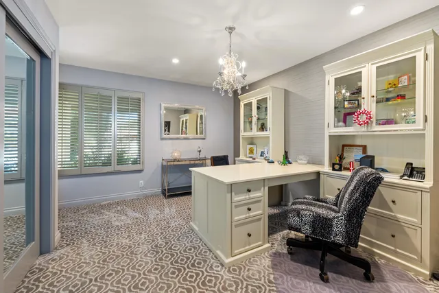 a view of a workspace with furniture and a window