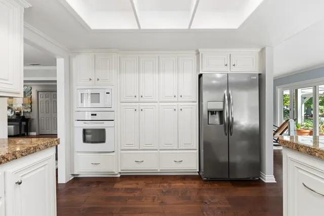 a kitchen with white cabinets and refrigerator