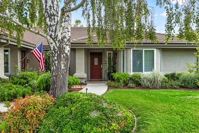 a view of a house with brick walls and a yard with plants