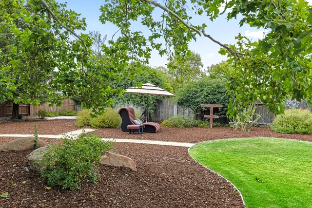 a view of a backyard with table and chairs and a slide