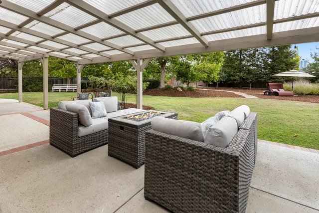 a view of a patio with couches chairs and a big yard