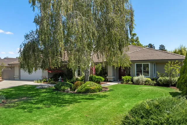 a view of a house with backyard garden and plants