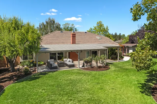 a front view of a house with garden and sitting area