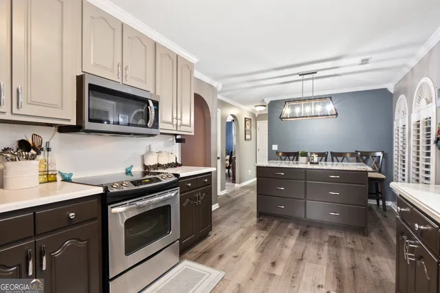 a kitchen with granite countertop a stove top oven microwave and cabinets