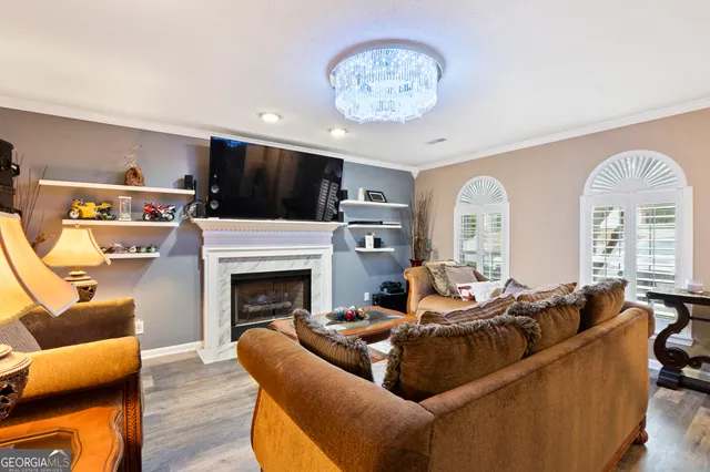 a living room with furniture a flat screen tv and a fireplace