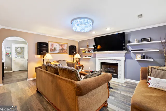a living room with furniture a flat screen tv and a fireplace