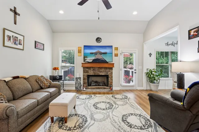 a living room with furniture a flat screen tv and a fireplace