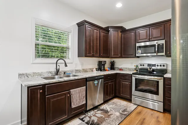 a kitchen with stainless steel appliances granite countertop a sink stove and microwave