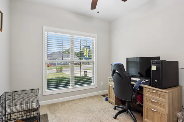a view of a workspace with furniture and a window