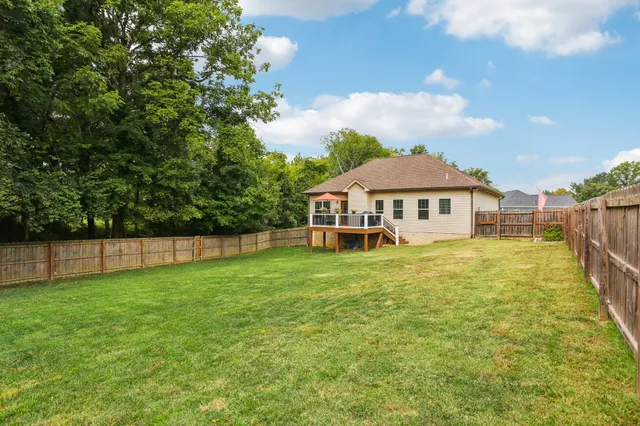 a view of a house with a big yard and large trees