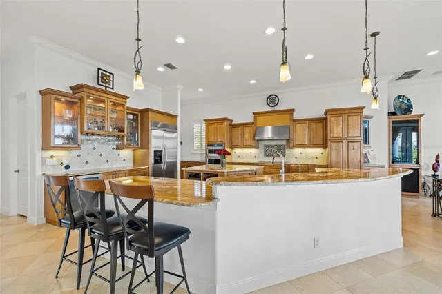 a kitchen with stainless steel appliances kitchen island granite countertop a stove a sink and a refrigerator