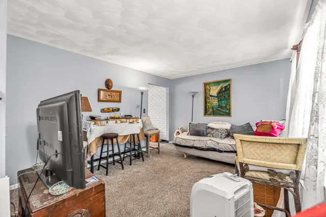 a living room with furniture a flat screen tv and a large window