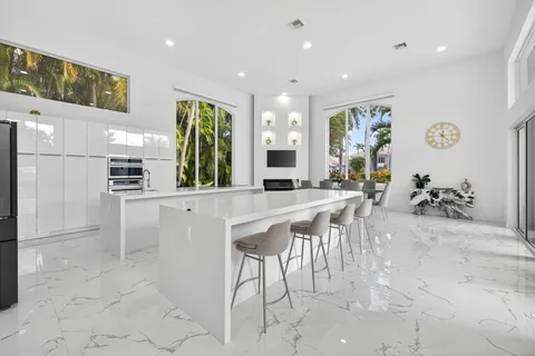 a kitchen with stainless steel appliances a table and chairs in it
