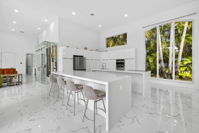 a large white kitchen with stainless steel appliances