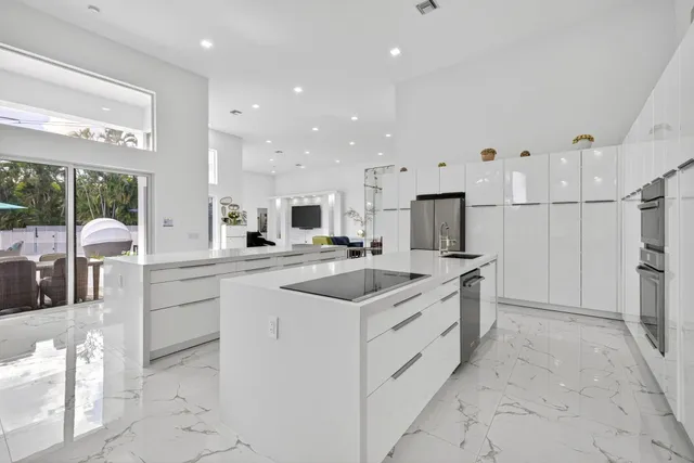 a kitchen with stainless steel appliances granite countertop a sink and a refrigerator