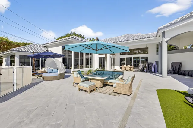 a view of a patio that has couches chairs and a wooden floor