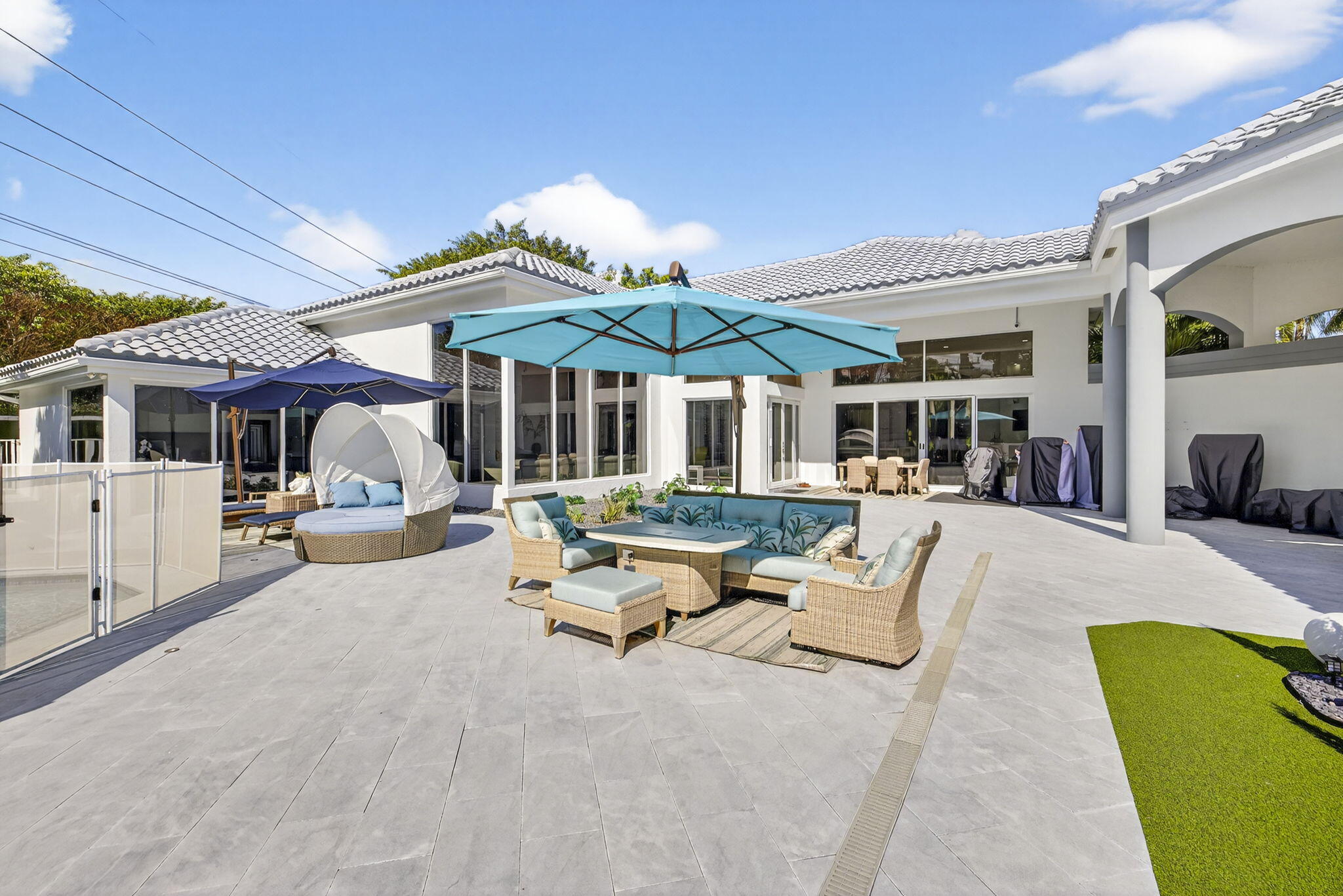 2673 Northwest 64th Boulevard Boca Raton, FL 33496 - Photo 44 of 64 a view of a patio with a table and chairs under an umbrella