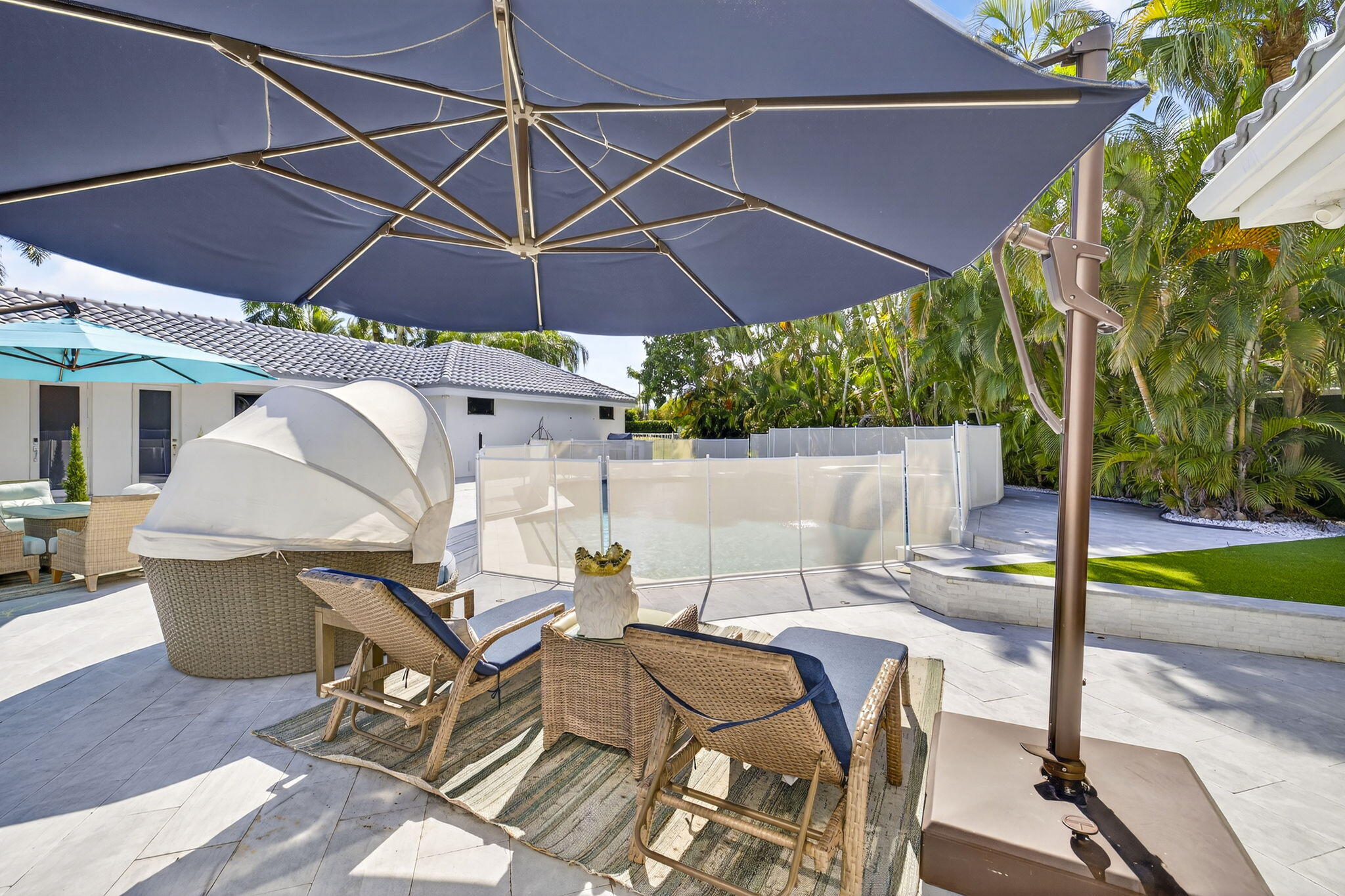 2673 Northwest 64th Boulevard Boca Raton, FL 33496 - Photo 46 of 64 a patio with a table and chairs under an umbrella