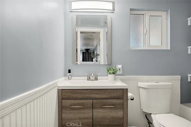 a bathroom with a sink vanity and a toilet