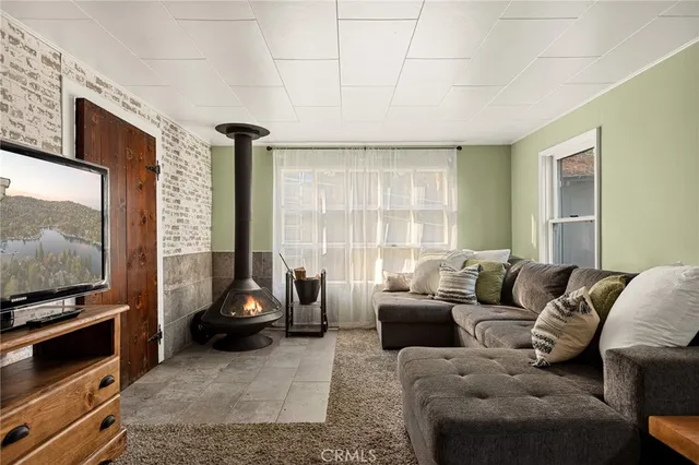 a living room with furniture a flat screen tv and a window