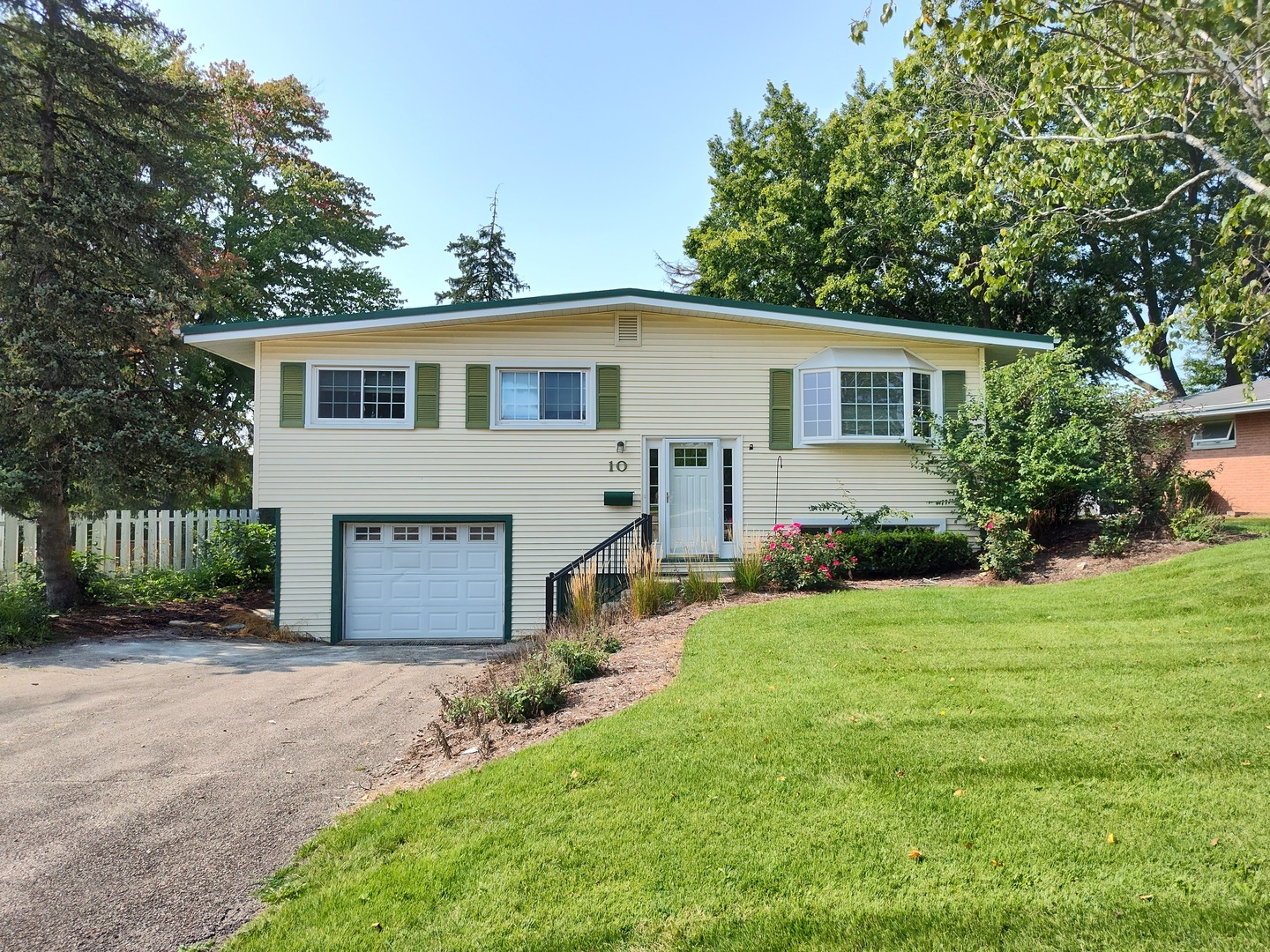 a front view of a house with a garden and yard