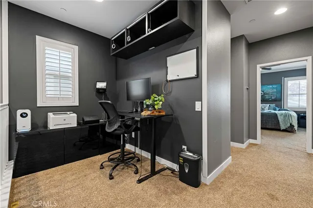 a view of a workspace with furniture and a window