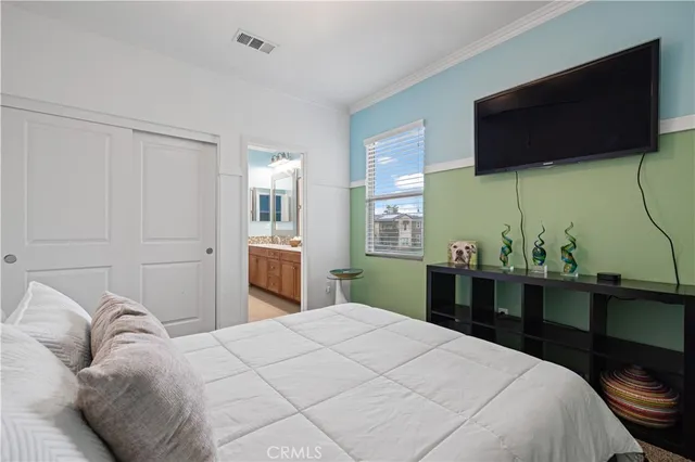 a bedroom with a bed and a flat screen tv