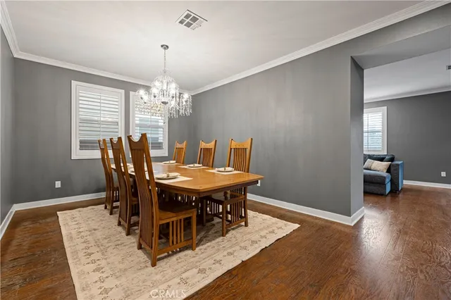 a dining room with furniture wooden floor a rug and a chandelier