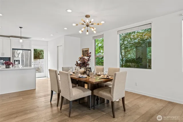 a dining room with furniture a large window and wooden floor