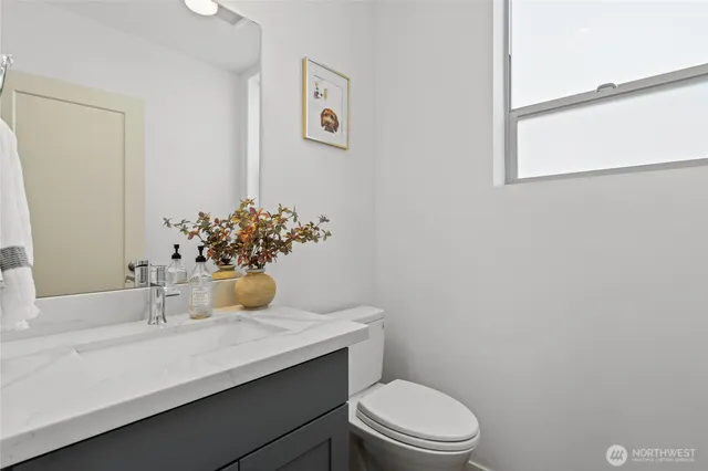 a bathroom with a sink a toilet and a mirror