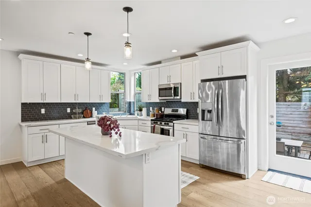 a kitchen with refrigerator a sink and white cabinets