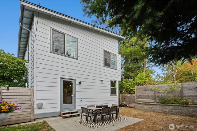 a view of a patio with table and chairs with wooden fence and plants