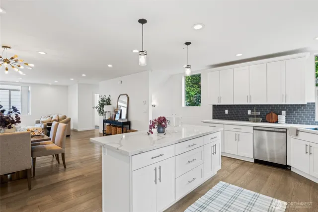 a large kitchen with kitchen island a sink stainless steel appliances and white cabinets