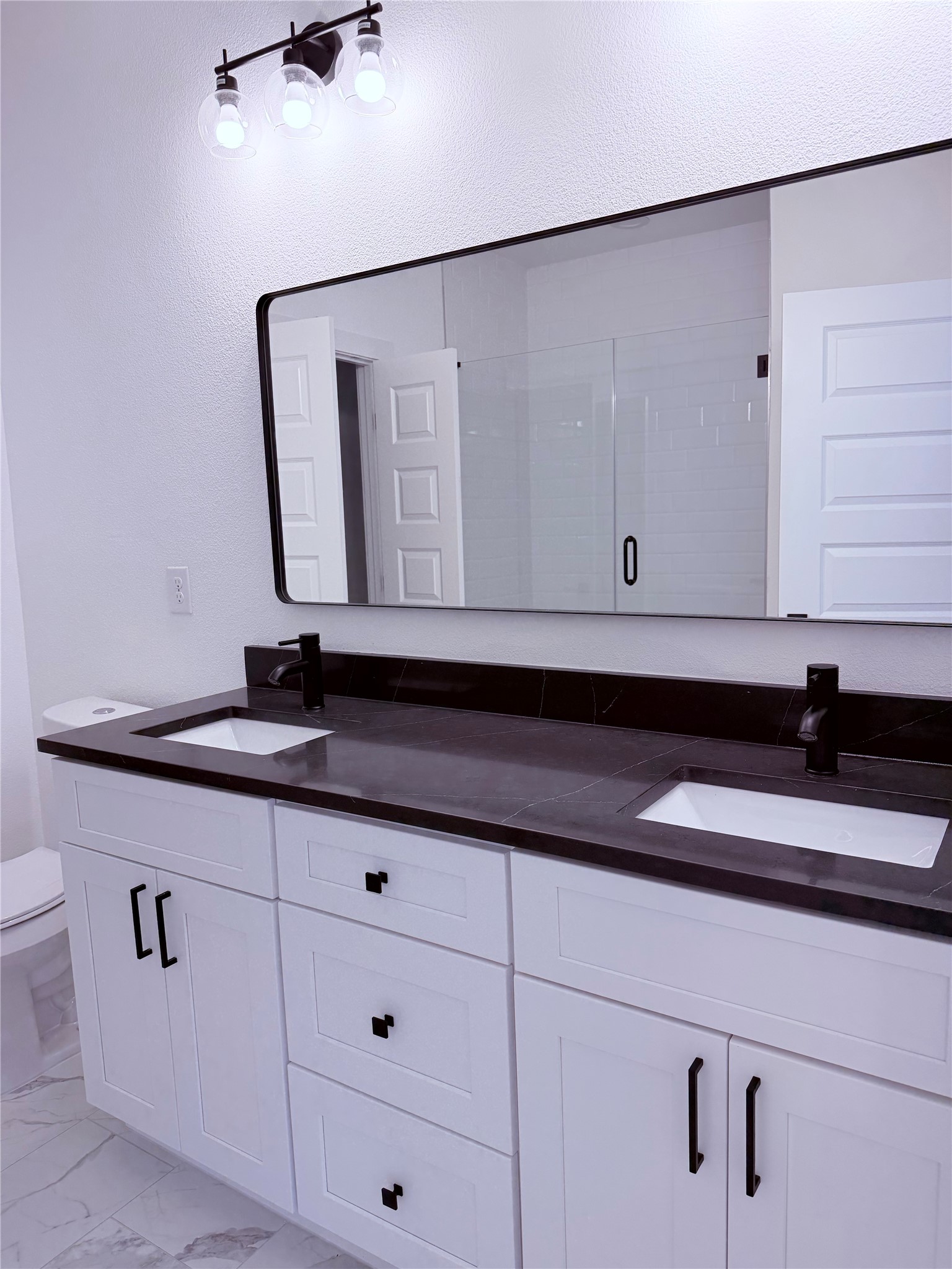 1417 Kramer Lane, Unit 7 Austin, TX 78758 - Photo 10 of 24 A well-appointed primary bathroom vanity boasts a double sink with rich stone counters.
