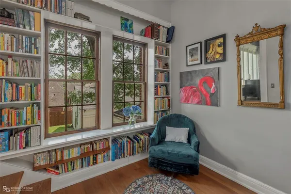 a living room with furniture book shelf and a window