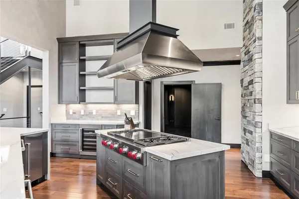 a kitchen with a stove and a wooden floor