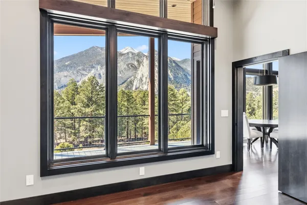 a view of a room that has a large window and wooden floor
