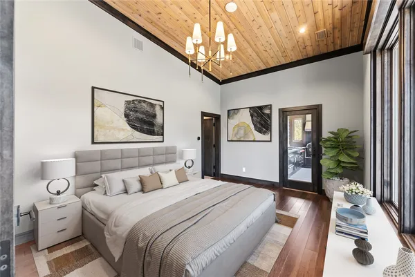 a bedroom with a large bed and a chandelier