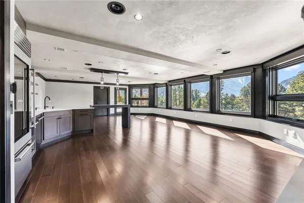 a kitchen with granite countertop lots of wooden cabinets a sink and appliances