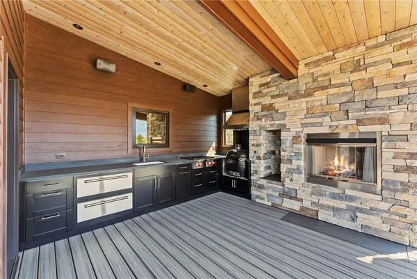 a view of a patio with a dining table and chairs with wooden floor and fence