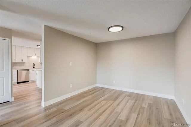 a view of a room with wooden floor and a bathroom