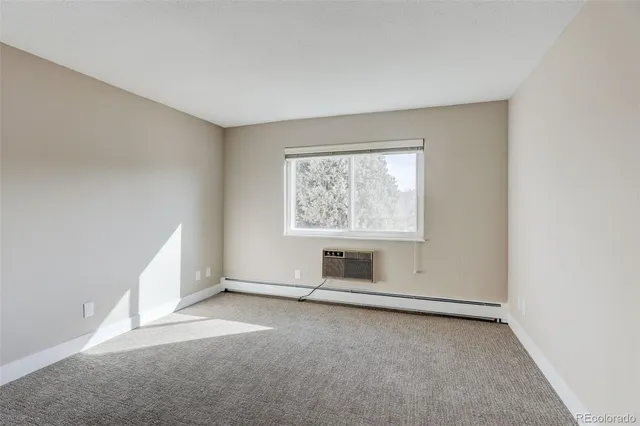 a view of an empty room with a window and fireplace