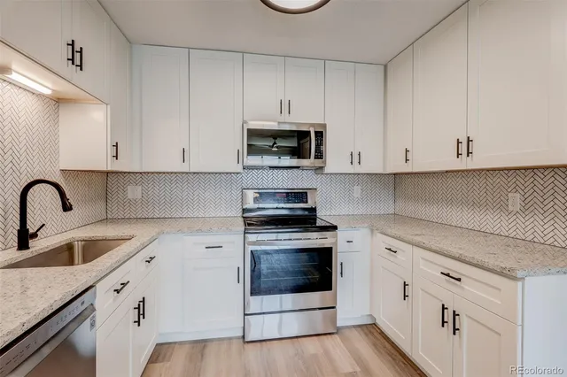 a kitchen with white cabinets and white appliances