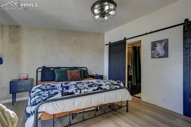 a bedroom with a bed painting on wall and a desk