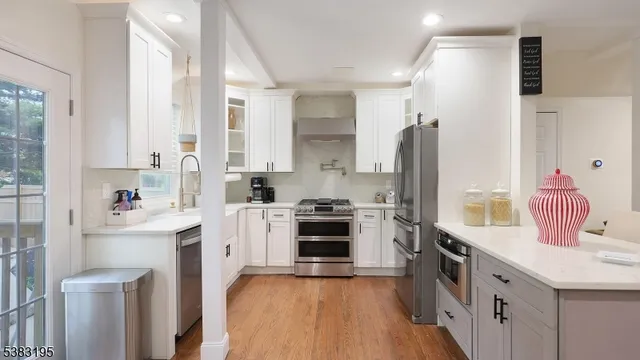 a kitchen with white cabinets and stainless steel appliances