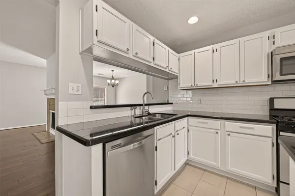 a kitchen with white cabinets sink and stove